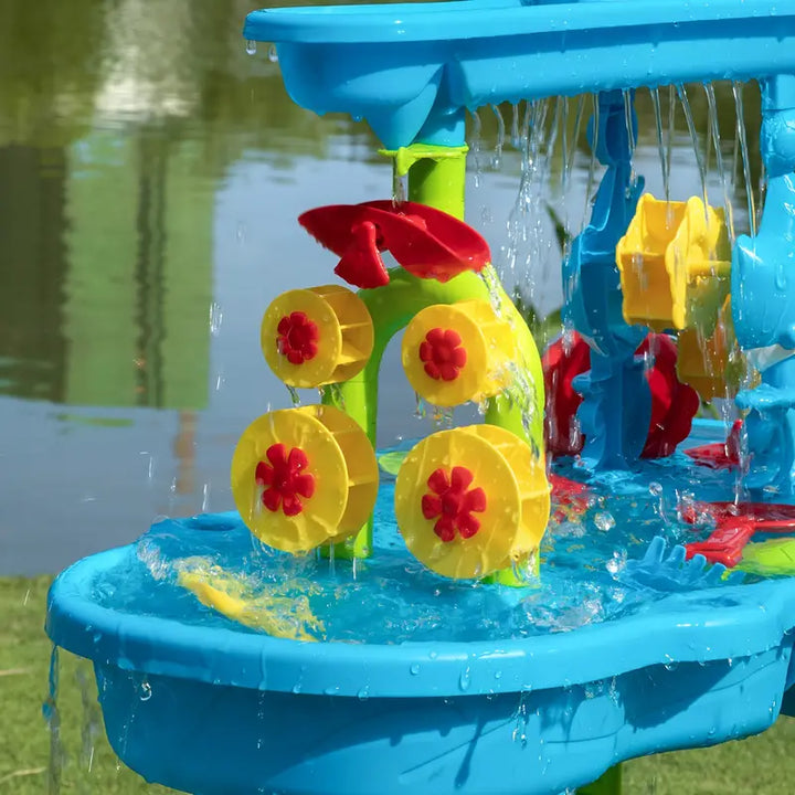 "3-laagse SplashTower zand- en watertafel met kleurrijke vakken voor creatief spelplezier, perfect voor zonnige dagen."