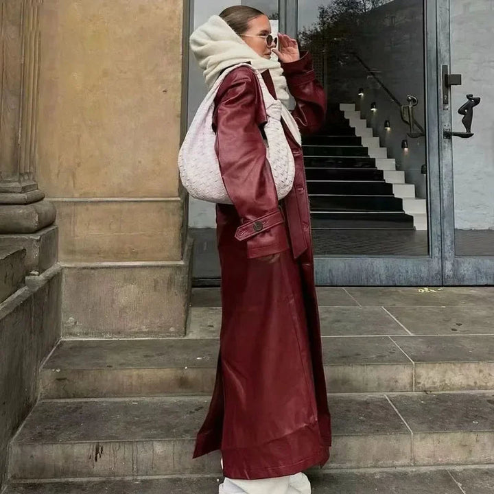 "Bordeauxrode imitatieleren damesjas, chique retrodesign met riem, opvallende diepe rode kleur voor een stijlvolle look."