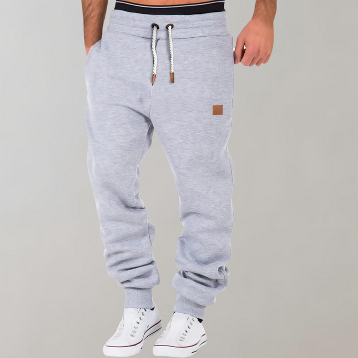 "Comfortabele heren joggingbroek met baggy pasvorm, grijs van kleur, verstelbare tailleband, ideaal voor sport en casual."