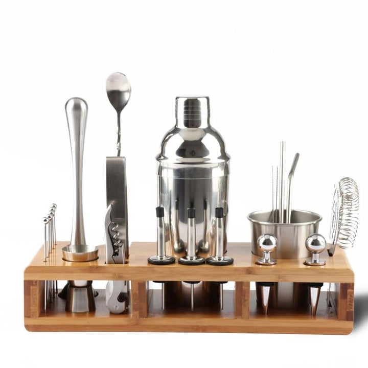 Complete cocktailshaker set met roestvrijstalen accessoires en houten standaard, ideaal voor thuisbars en bartenders.
