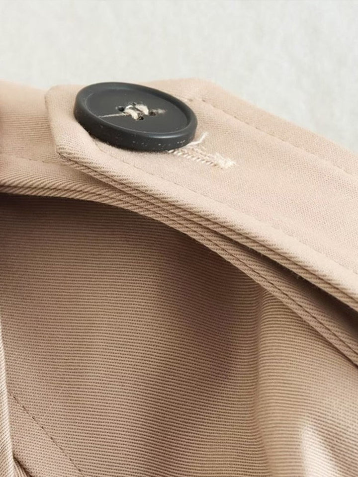 "Cropped beige trenchcoat voor dames, stijlvolle dubbele rij knopen en verstelbare manchetten, elegant en modern ontwerp."