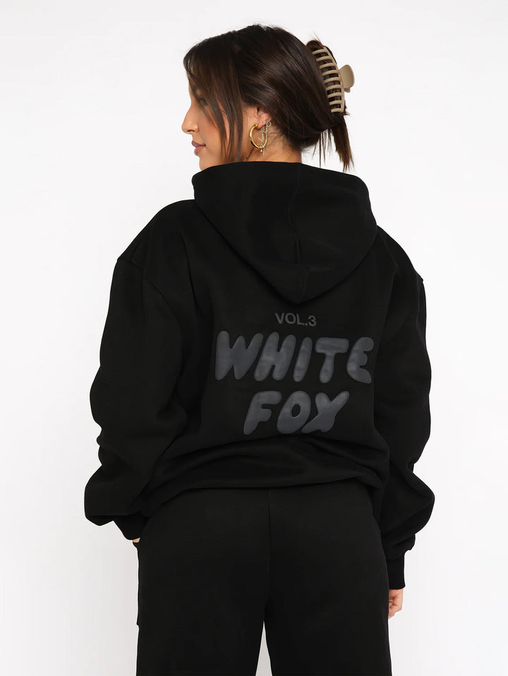 "Dames trainingspak met oversized pasvorm, wit, elastische ribboorden, trendy puffprint logo en fleecestof."