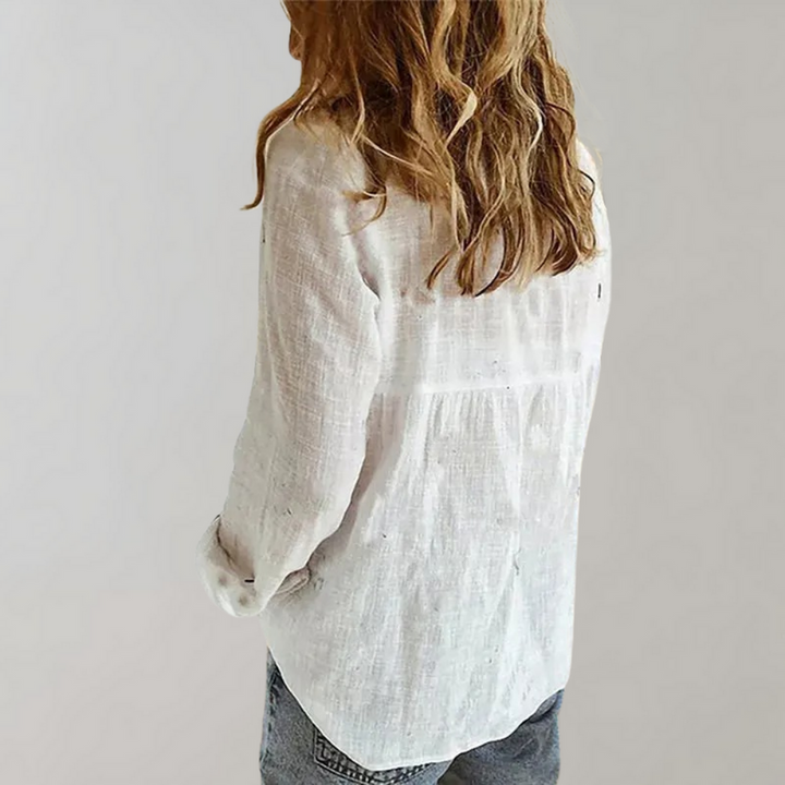 "Damesblouse van luchtig katoen met tijdloos design, losse pasvorm, opgerolde mouwen en knoopsluiting, zijaanzicht."