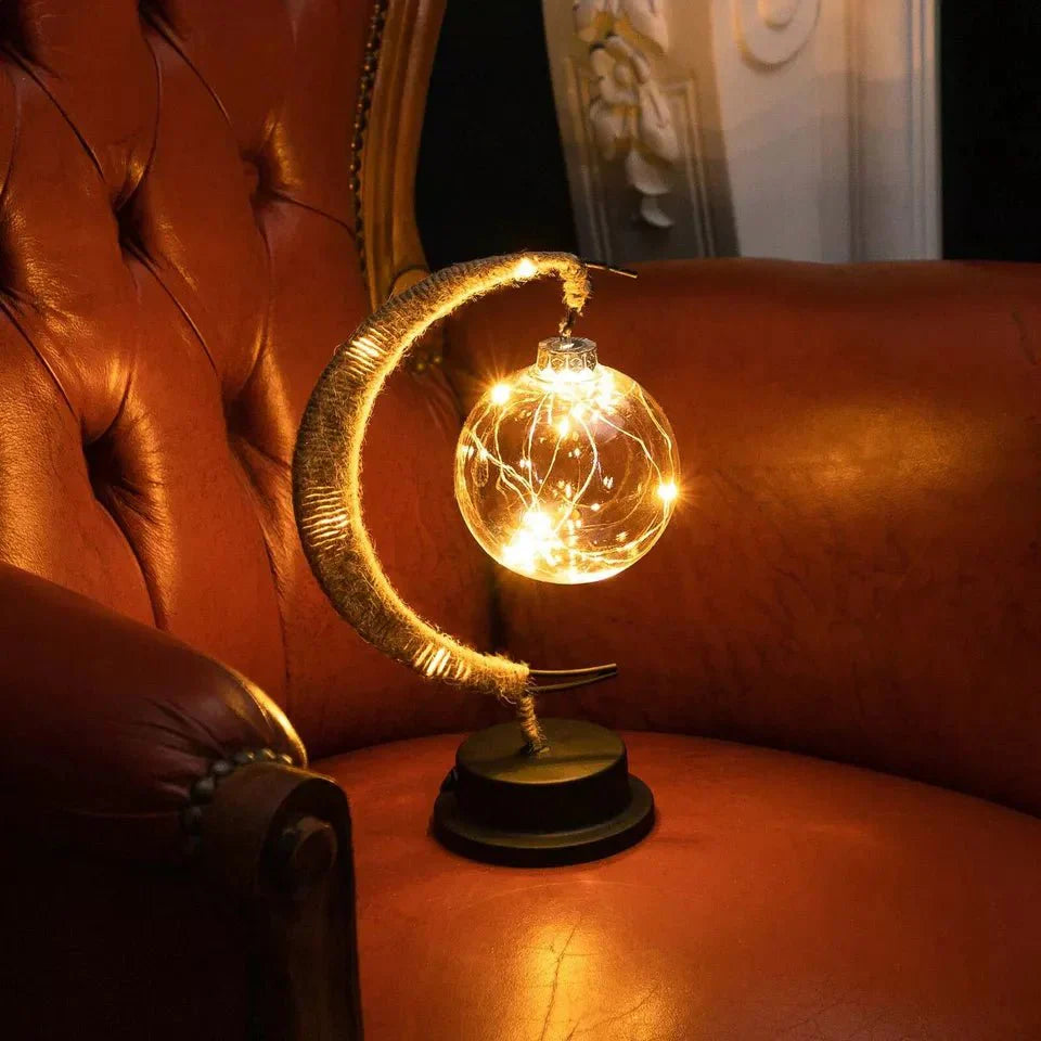 "Dromerige maanlamp van borosilicaatglas met zachte LED-gloed, creëert een betoverende sfeer op tafel."