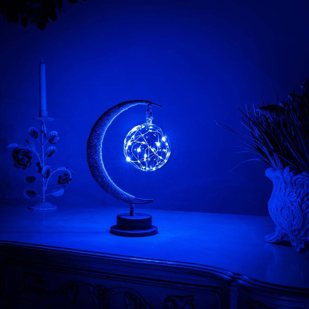 "Dromerige maanlamp van borosilicaatglas met zachte LED-gloed, creëert een betoverende sfeer op tafel."
