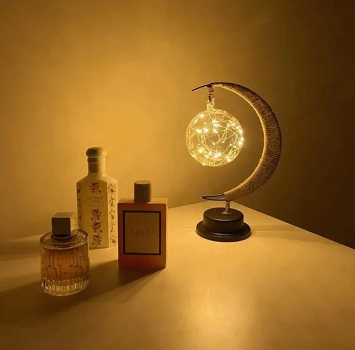 "Dromerige maanlamp van borosilicaatglas met zachte LED-gloed, creëert een betoverende sfeer op tafel."