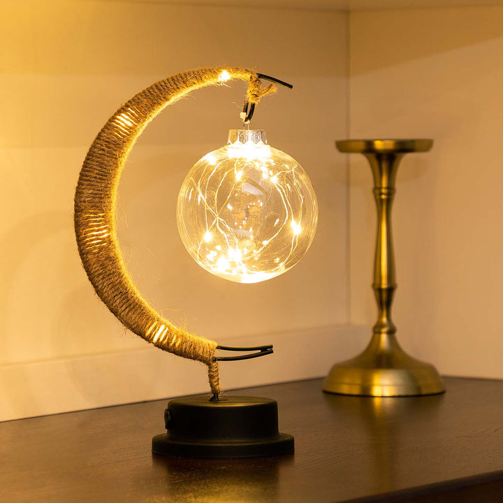 "Dromerige maanlamp van borosilicaatglas met zachte LED-gloed, creëert een betoverende sfeer op tafel."