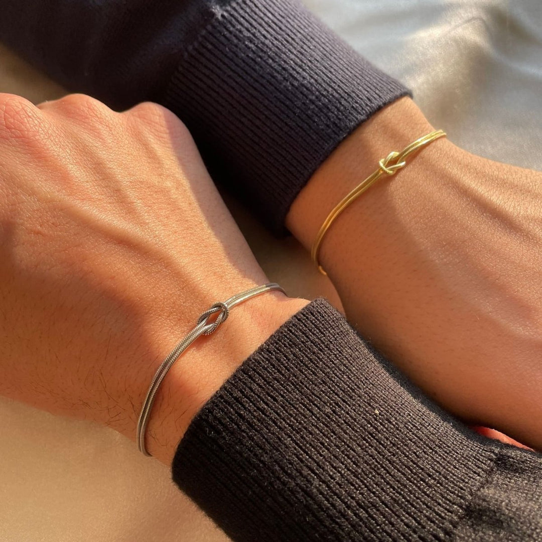 "Elegant damesarmband met liefdesknoopdesign, verstelbaar, minimalistisch en stijlvol in goud of zilverkleur."