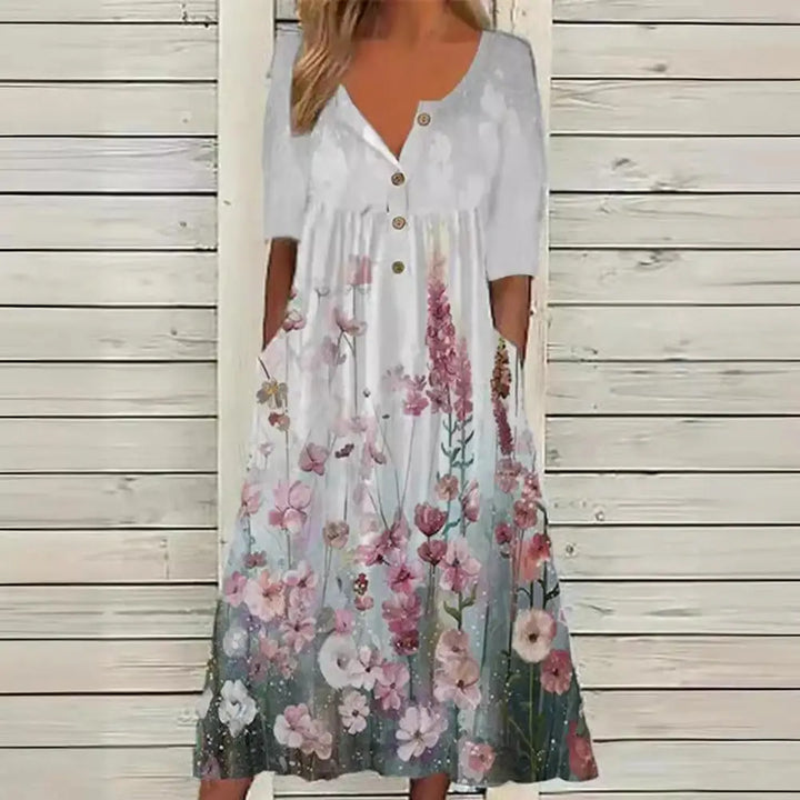 Elegante A-lijn midi jurk met levendige bloemenprint en praktische zakken, ideaal voor zomerse en stijlvolle dagen.