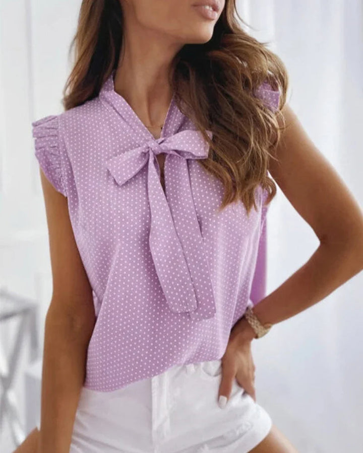 "Elegante Brianna damesblouse met polkadots, strikdetail en ruffles; luchtige zomertop voor veelzijdige stijl."