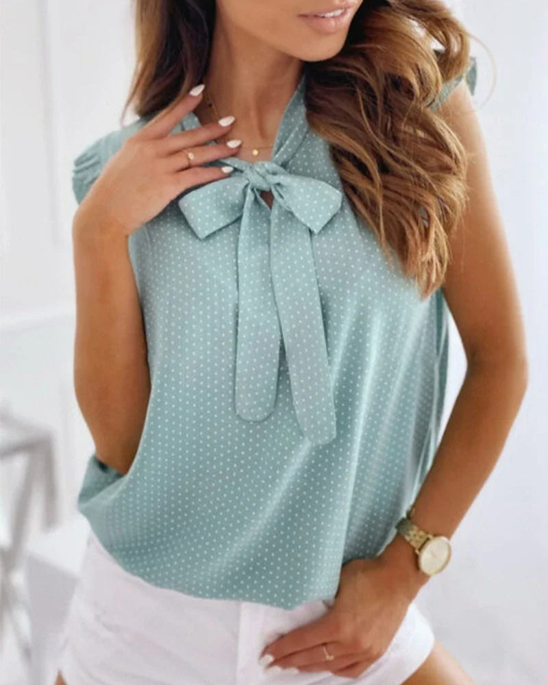 "Elegante Brianna damesblouse met polkadots, strikdetail en ruffles; luchtige zomertop voor veelzijdige stijl."