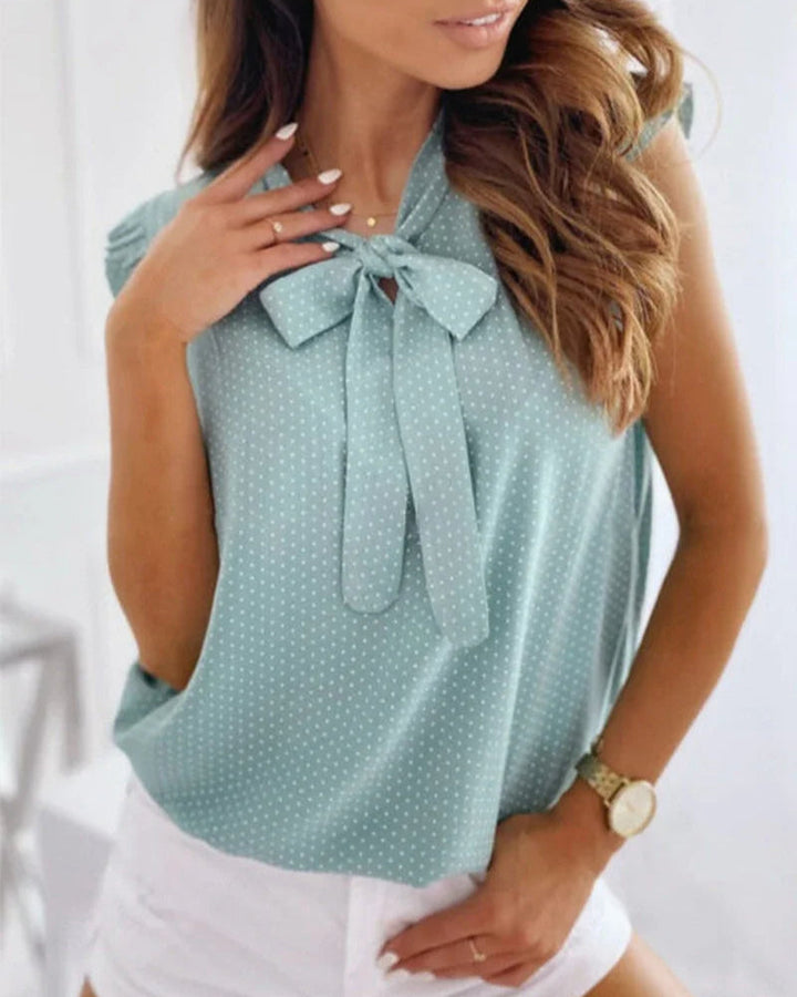 "Elegante Brianna damesblouse met polkadots, strikdetail en ruffles; luchtige zomertop voor veelzijdige stijl."