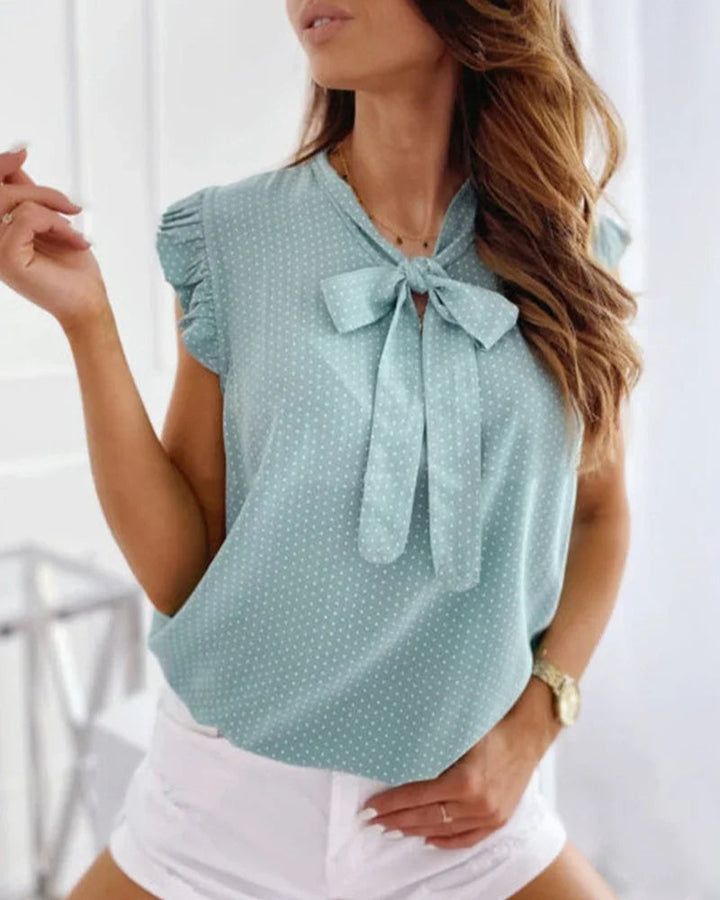 "Elegante Brianna damesblouse met polkadots, strikdetail en ruffles; luchtige zomertop voor veelzijdige stijl."