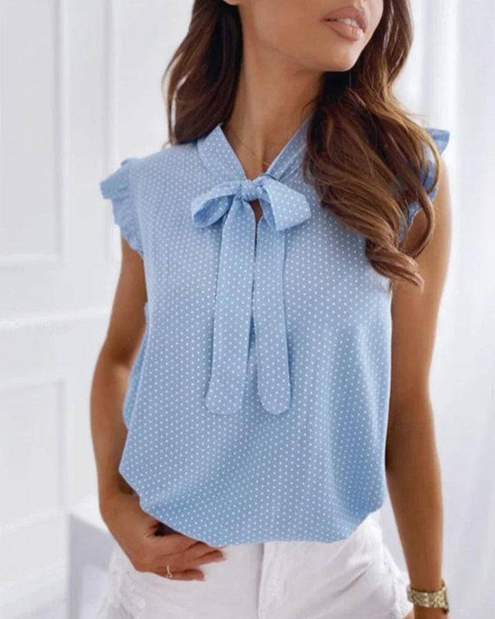 "Elegante Brianna damesblouse met polkadots, strikdetail en ruffles; luchtige zomertop voor veelzijdige stijl."