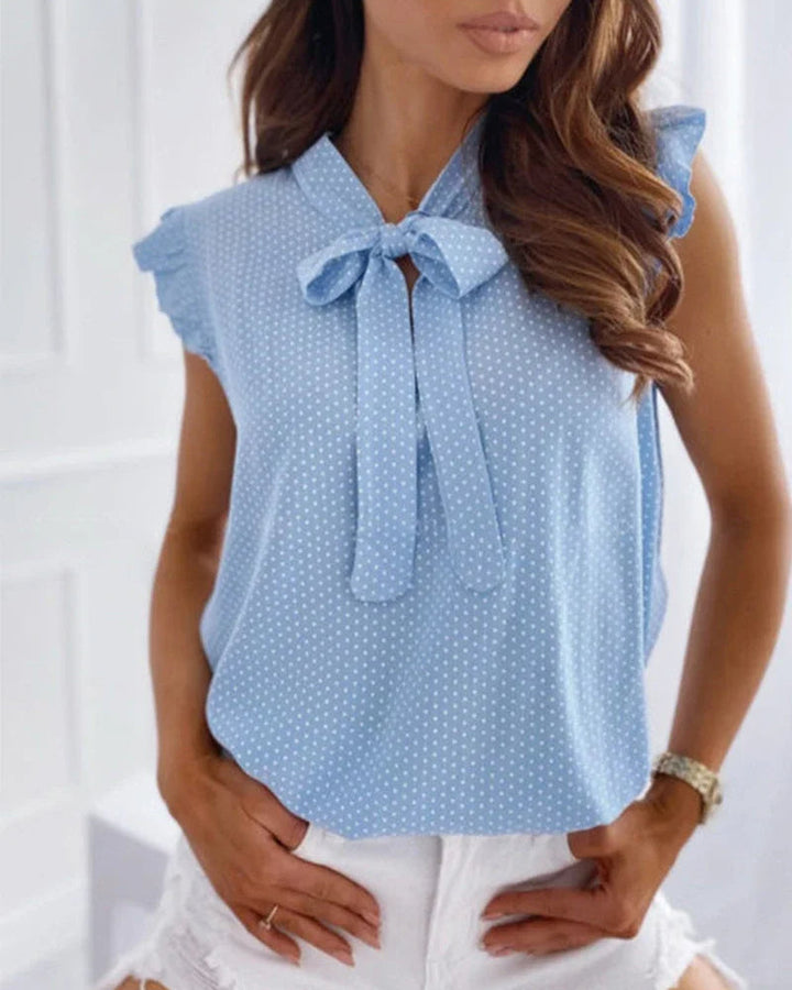 "Elegante Brianna damesblouse met polkadots, strikdetail en ruffles; luchtige zomertop voor veelzijdige stijl."