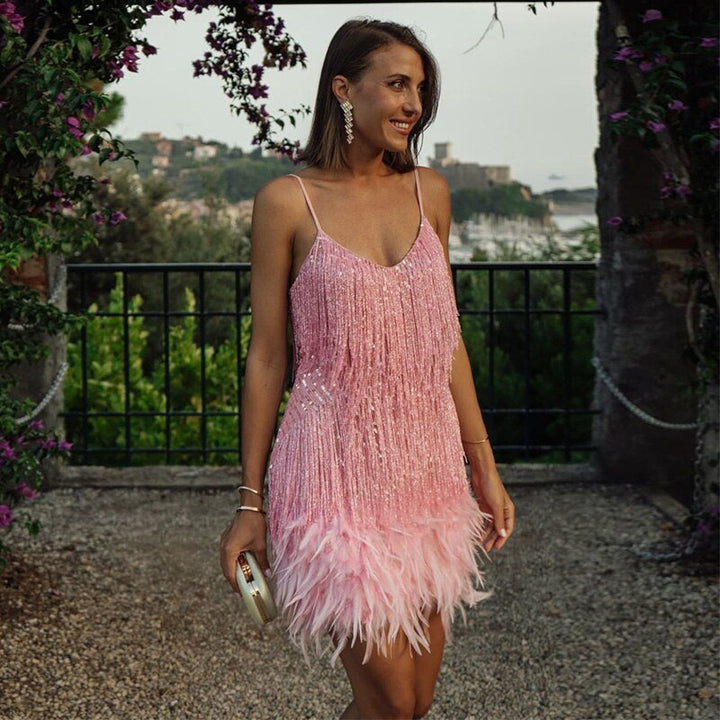 "Elegante cocktailjurk met franjes en veertjes, perfect voor feestjes, met aansluitende pasvorm en uitlopende rok."