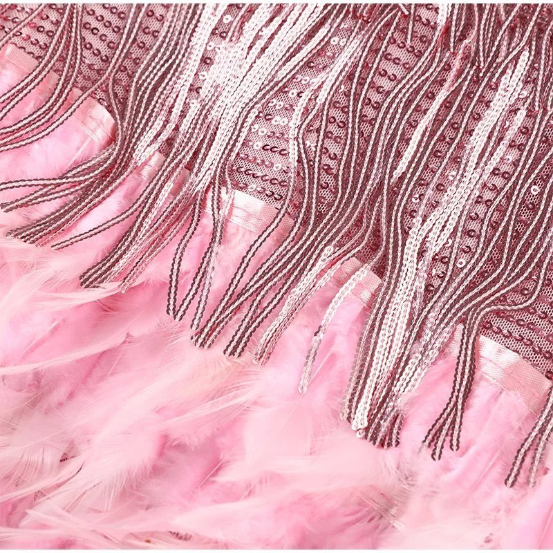 "Elegante cocktailjurk met franjes en veertjes, perfect voor feestjes, met aansluitende pasvorm en uitlopende rok."