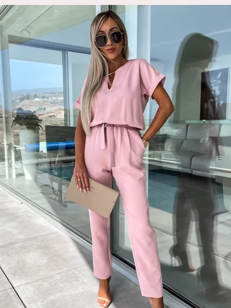 "Elegante Elara jumpsuit V-hals, trendy en comfortabel in donkerroze, elastische taille en luchtige broekspijpen."