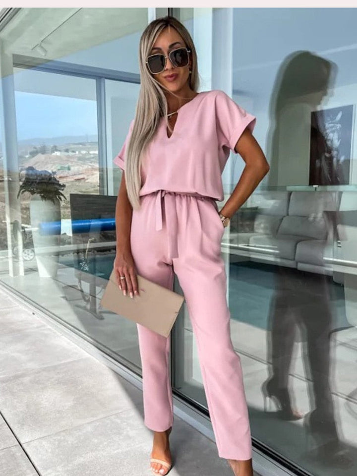 "Elegante Elara jumpsuit V-hals, trendy en comfortabel in donkerroze, elastische taille en luchtige broekspijpen."