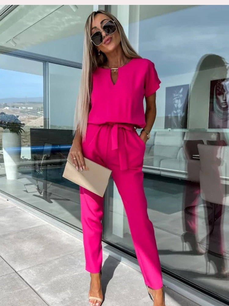 "Elegante Elara jumpsuit V-hals, trendy en comfortabel in donkerroze, elastische taille en luchtige broekspijpen."
