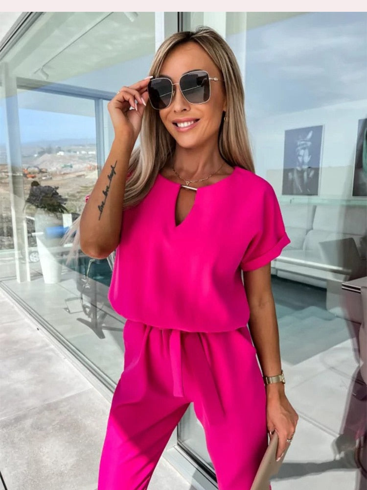 "Elegante Elara jumpsuit V-hals, trendy en comfortabel in donkerroze, elastische taille en luchtige broekspijpen."