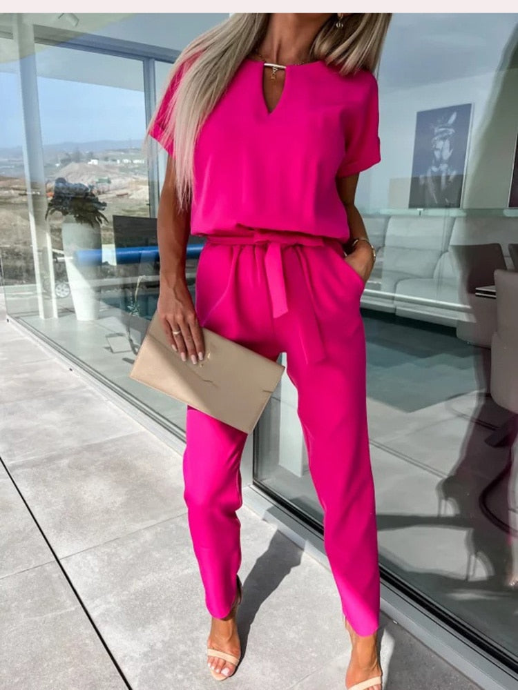 "Elegante Elara jumpsuit V-hals, trendy en comfortabel in donkerroze, elastische taille en luchtige broekspijpen."
