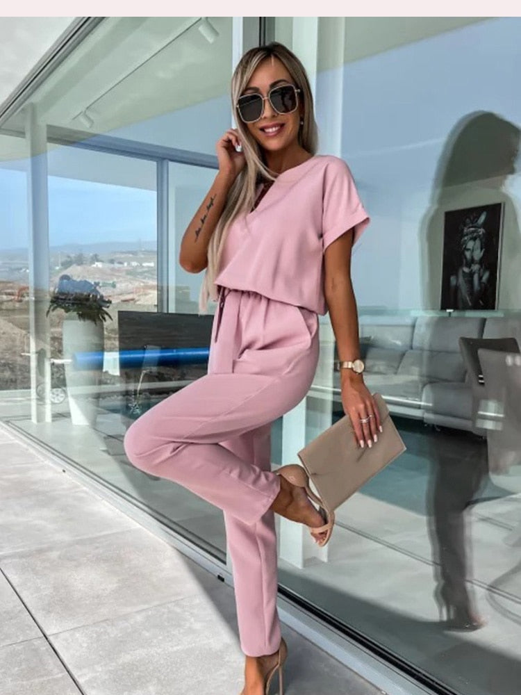 "Elegante Elara jumpsuit V-hals, trendy en comfortabel in donkerroze, elastische taille en luchtige broekspijpen."
