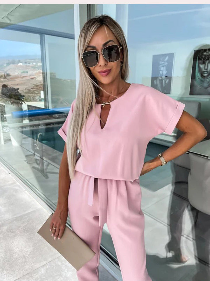 "Elegante Elara jumpsuit V-hals, trendy en comfortabel in donkerroze, elastische taille en luchtige broekspijpen."