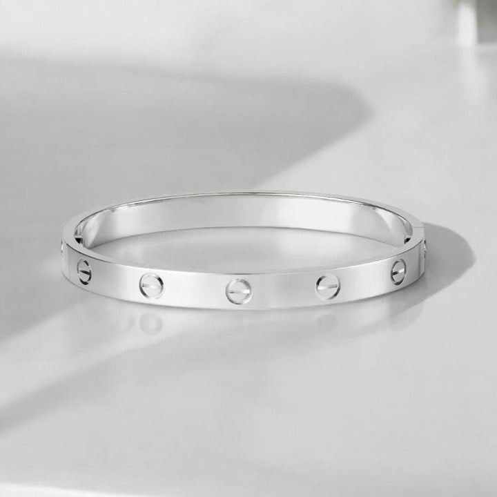 "Elegante gouden armband met tijdloos design en schroefdetails, een verfijnd en luxueus accessoire voor elke gelegenheid."