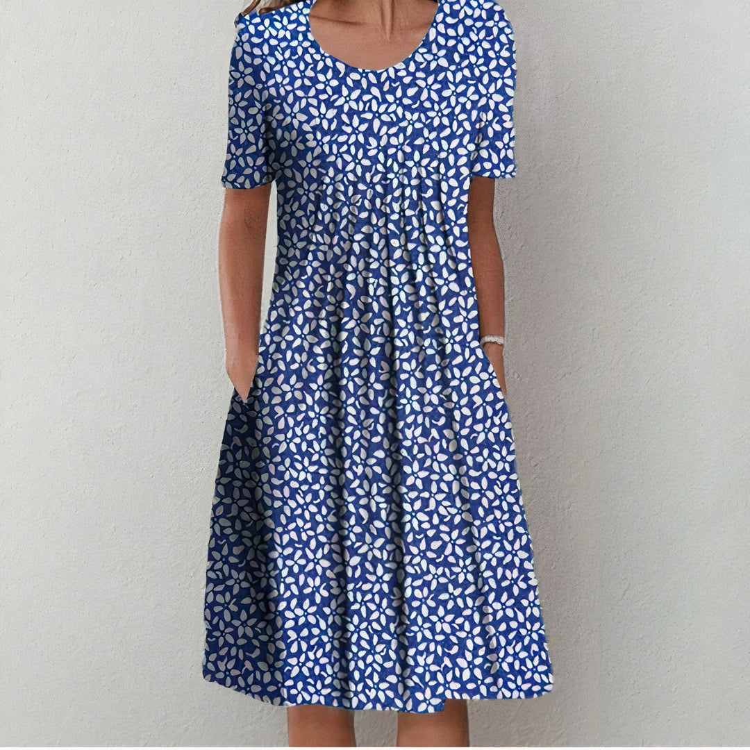 "Elegante katoenen jurk, licht getailleerd, zacht en ademend in blauw met bloemenpatroon, tijdloos ontwerp."