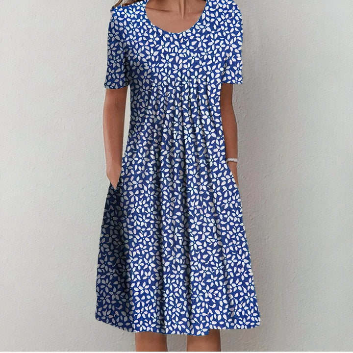 "Elegante katoenen jurk, licht getailleerd, zacht en ademend in blauw met bloemenpatroon, tijdloos ontwerp."