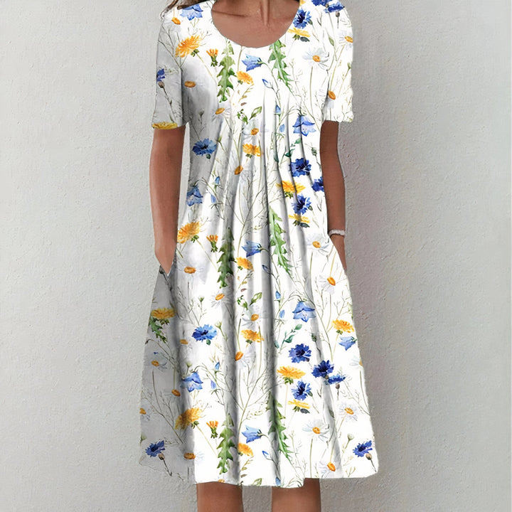 "Elegante katoenen jurk, licht getailleerd, zacht en ademend in blauw met bloemenpatroon, tijdloos ontwerp."