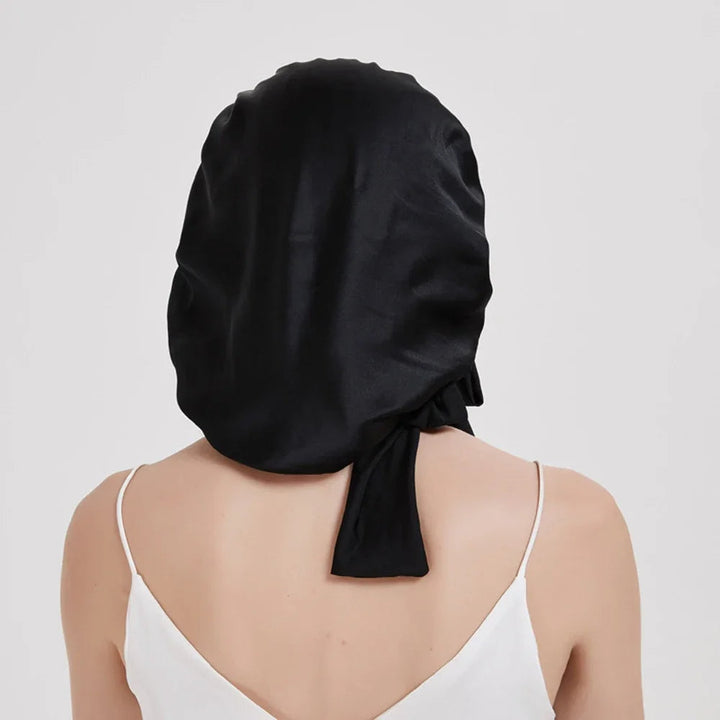 "Elegante moerbeizijden slaapmuts voor vrouwen met verstelbare band, close-up op luxe materiaal en satijnen afwerking."