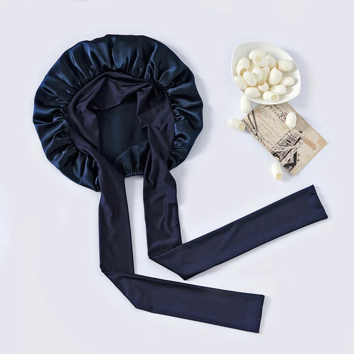 "Elegante moerbeizijden slaapmuts voor vrouwen met verstelbare band, close-up op luxe materiaal en satijnen afwerking."