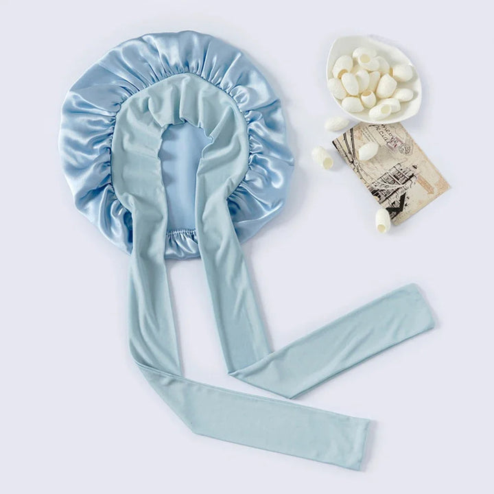 "Elegante moerbeizijden slaapmuts voor vrouwen met verstelbare band, close-up op luxe materiaal en satijnen afwerking."