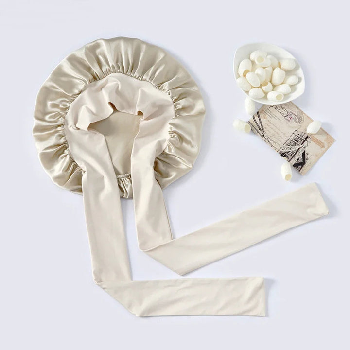 "Elegante moerbeizijden slaapmuts voor vrouwen met verstelbare band, close-up op luxe materiaal en satijnen afwerking."