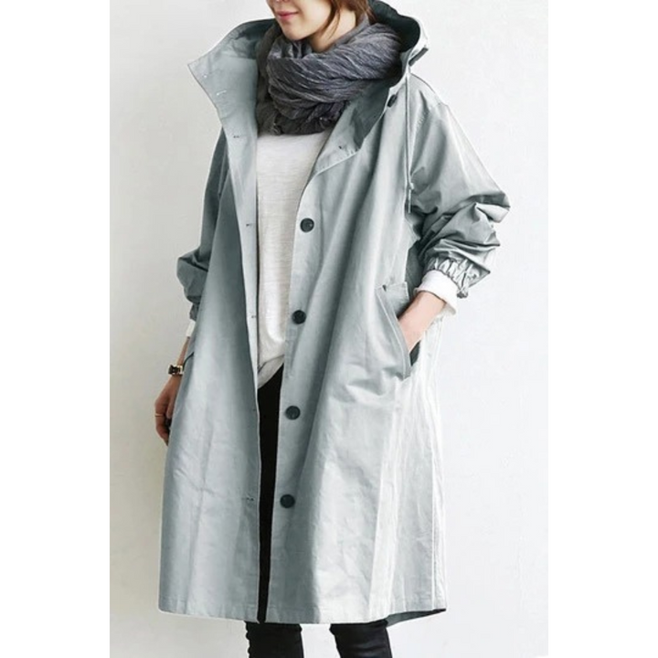 "Esmée lange dames trenchcoat zwart, elegant, wind- en waterdicht met capuchon en verstelbare taille voor perfecte pasvorm."