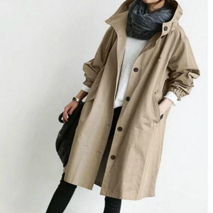 "Esmée lange dames trenchcoat zwart, elegant, wind- en waterdicht met capuchon en verstelbare taille voor perfecte pasvorm."