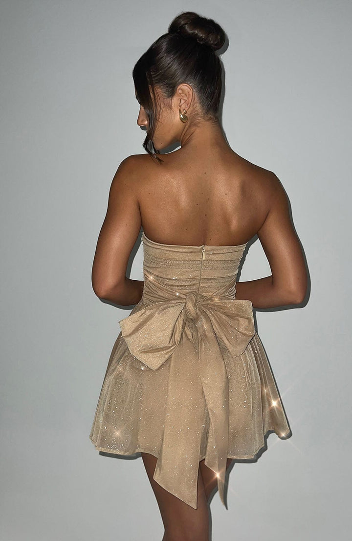 "Glimmende strapless mini-jurk met gouden glitters, flared rok en oversized strik - perfecte partyjurk voor dames."