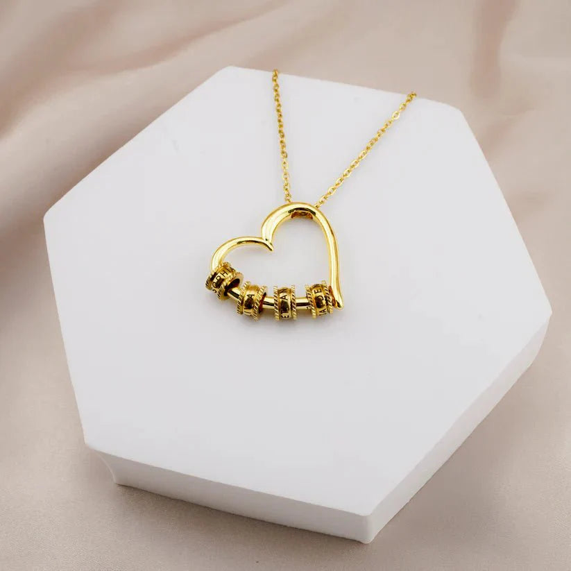 Hartvormige ketting voor moeder met gegraveerde namen, verguld roestvrij staal, gepresenteerd in luxe verpakking.