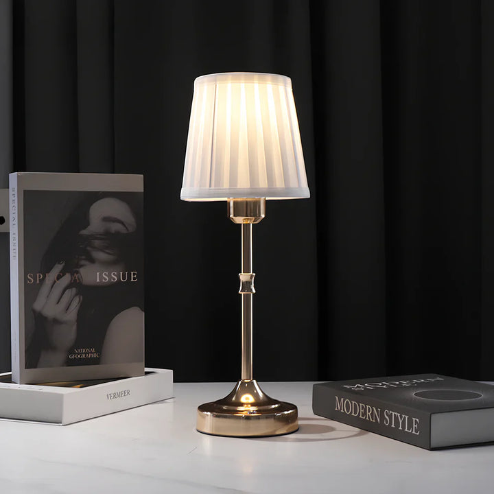 "Klassieke tafellamp met metalen frame en stoffen kap in een interieur, draadloos met drie lichtstanden."