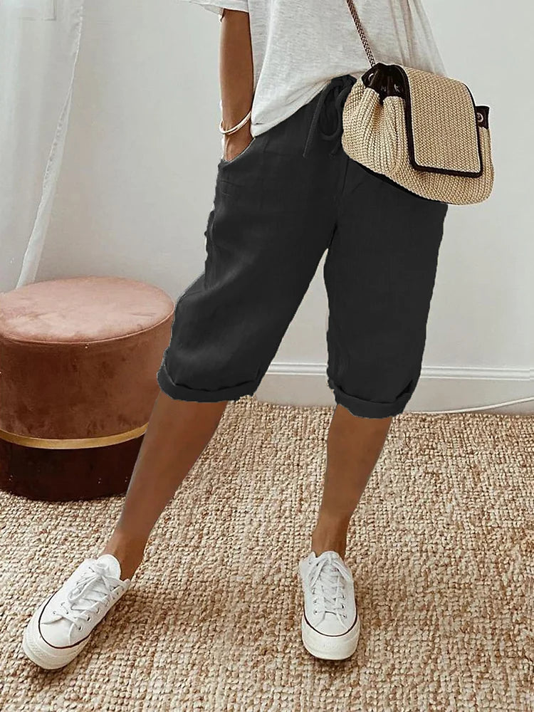 "Korte beige linnen zomerbroek dames, luchtige stof, eenvoudig ontwerp, ideaal voor warme dagen."