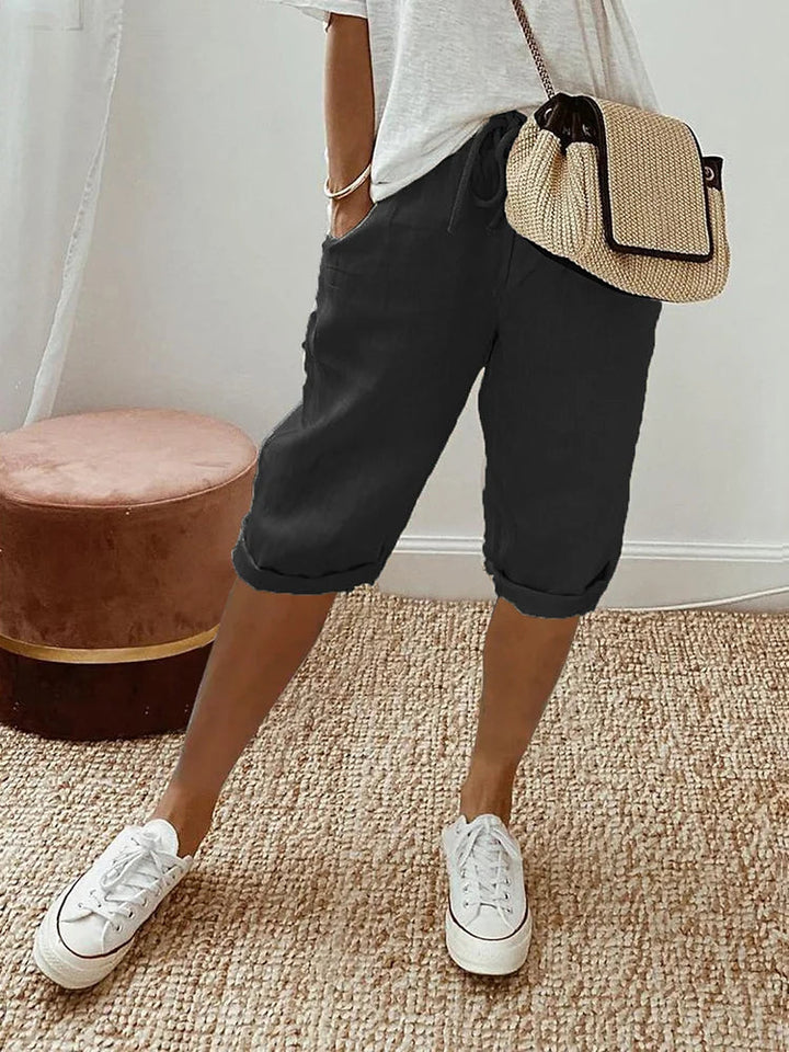 "Korte beige linnen zomerbroek dames, luchtige stof, eenvoudig ontwerp, ideaal voor warme dagen."