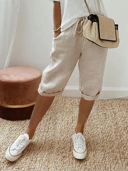 "Korte beige linnen zomerbroek dames, luchtige stof, eenvoudig ontwerp, ideaal voor warme dagen."