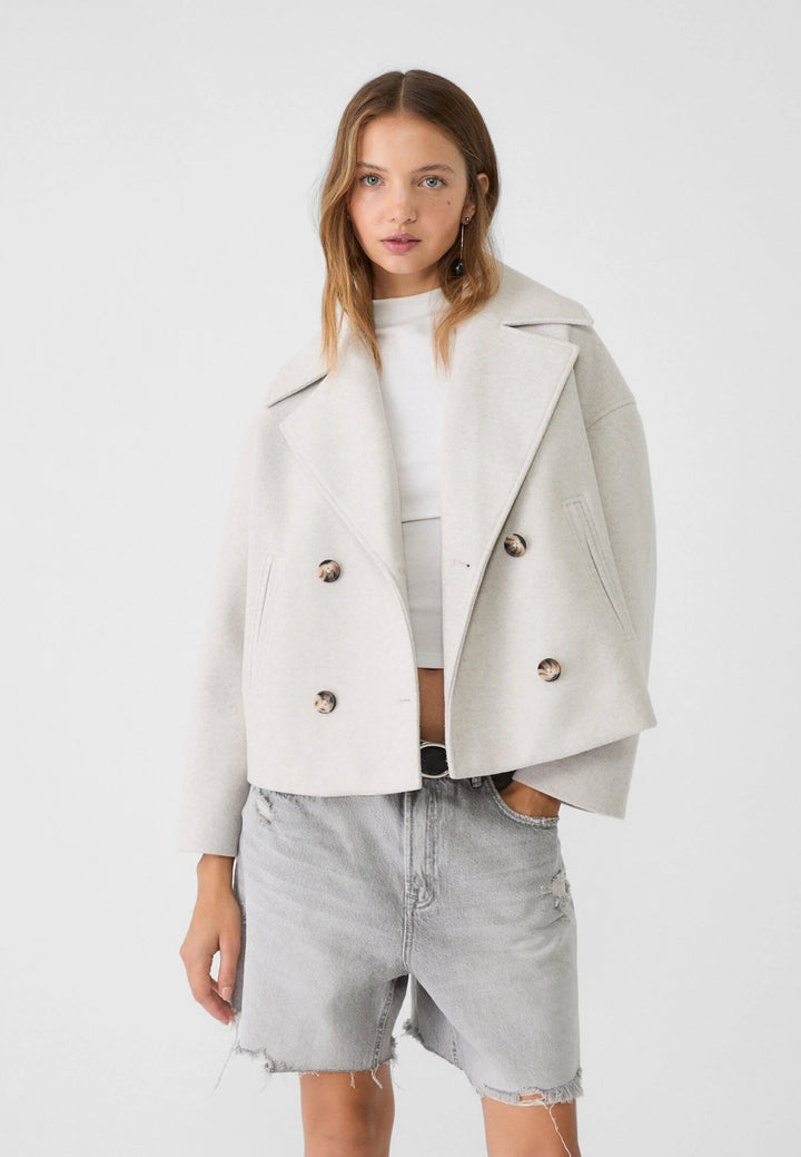 "Korte double-breasted jas, beige, regular fit, katoenmix, met knopen en zakken geschikt voor herfst- en wintermaanden."