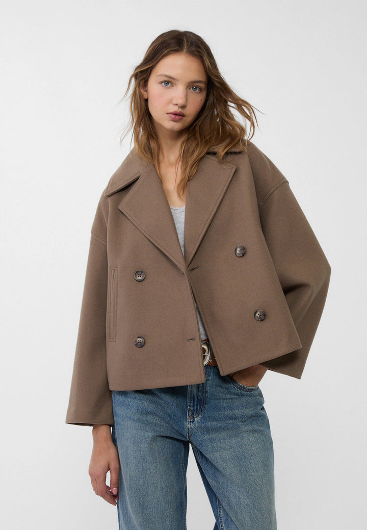 "Korte double-breasted jas, beige, regular fit, katoenmix, met knopen en zakken geschikt voor herfst- en wintermaanden."