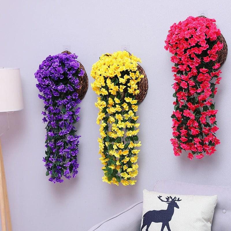 "Kunstmatige hangbloem in levendige kleuren, onderhoudsvrije decoratie voor woning of tuin, opgehangen tegen een muur."