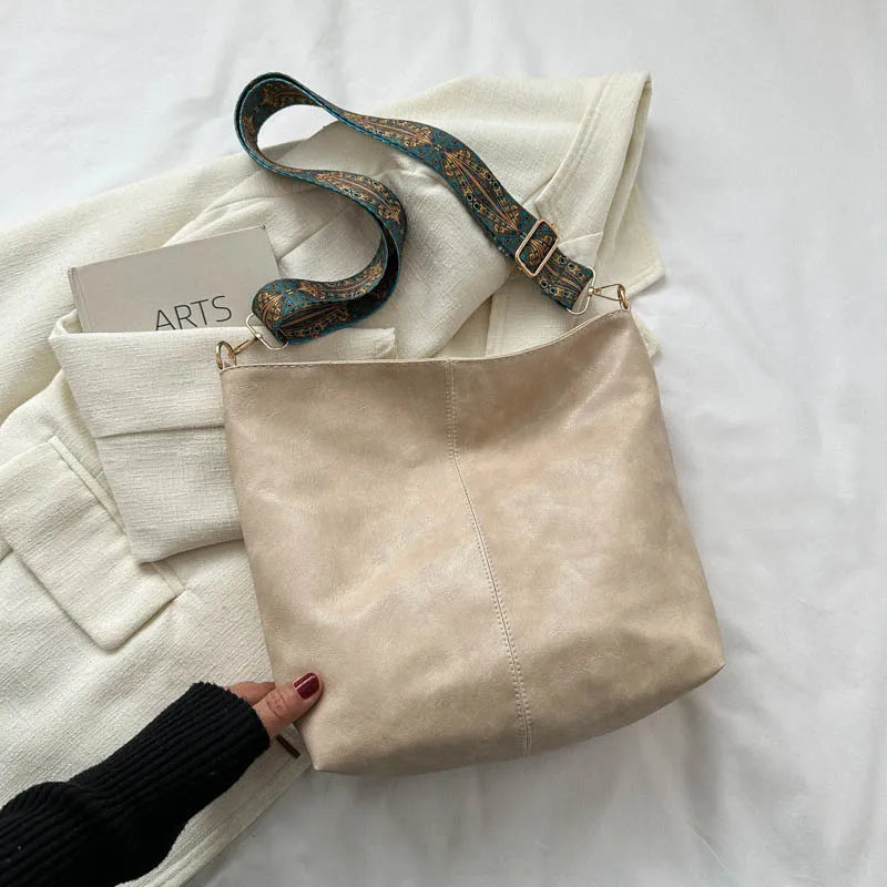 "Lichtbruine vintage leren schoudertas voor dames, elegant en stijlvol met verstelbare riem en ruim interieur."