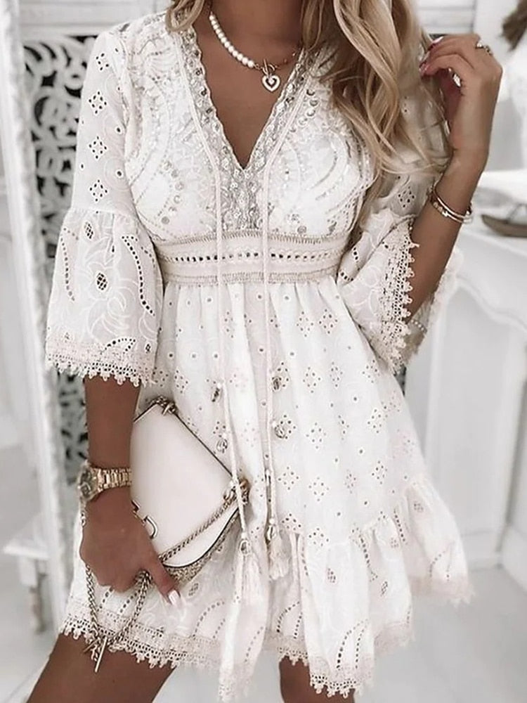 "Luchtige boho zomerjurk met geborduurde details, V-hals en flair mouwen voor elegante, casual stijl."