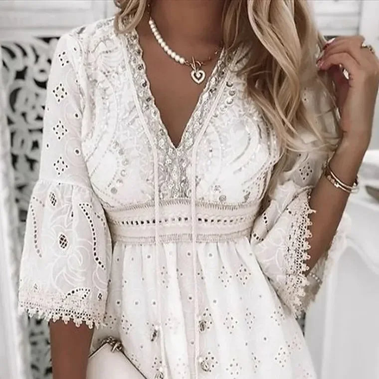 "Luchtige boho zomerjurk met geborduurde details, V-hals en flair mouwen voor elegante, casual stijl."